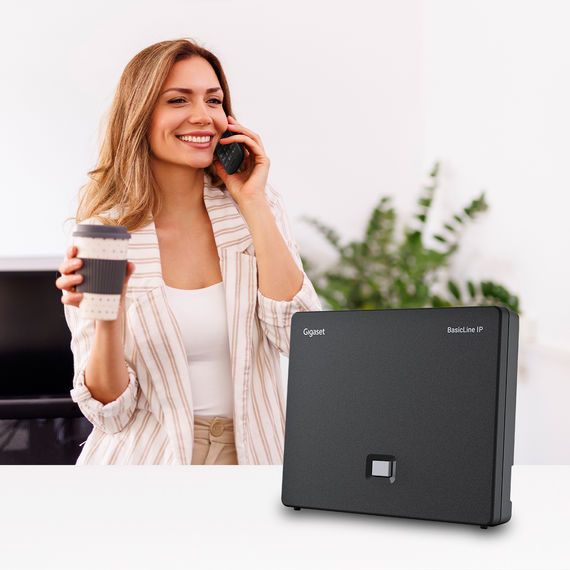 Gigaset BasicLine IP base station in a home office with user on a call