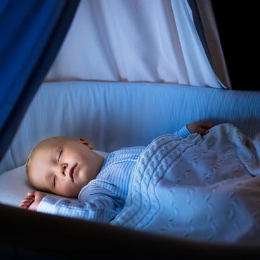 Sleeping baby in a cot with a soft night light, scene with a calming atmosphere.