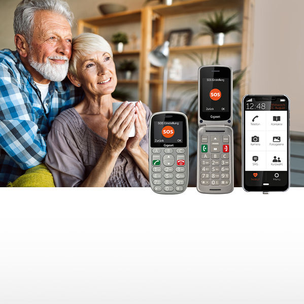 Das Bild zeigt ein älteres Ehepaar mit einer Auswahl von einfach zu bedienenden Smartphones und Handys. Link zur Kategorie Seniorenhandys.