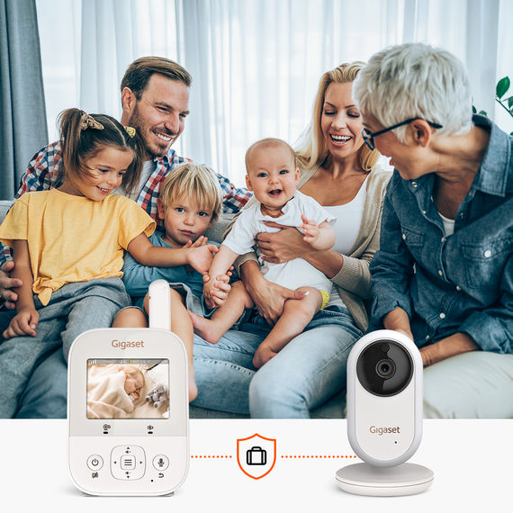 Mehrgenerationenfamilie sitzt fröhlich zusammen auf dem Sofa; das Gigaset BABY 300 Video-Babyphone bietet gleichzeitig Bild und Tonüberwachung.