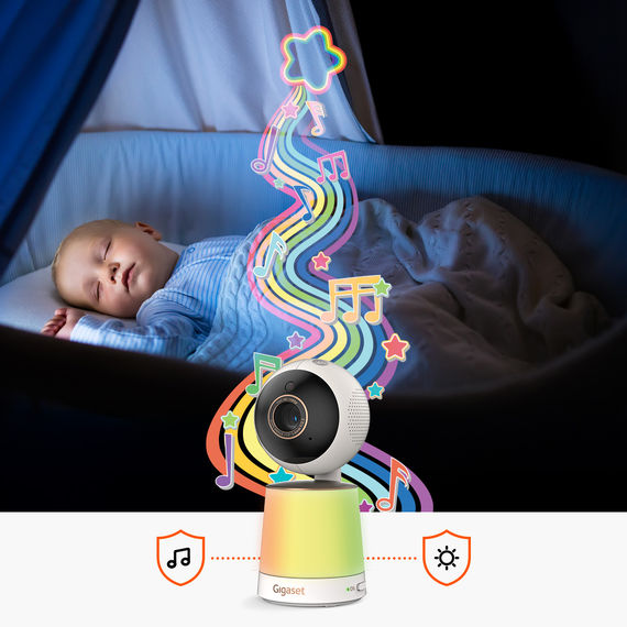 Bébé dort paisiblement dans son lit, les notes de musique et les effets de lumière colorée symbolisent les berceuses et la veilleuse de la caméra.