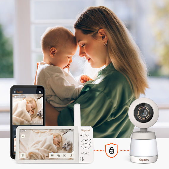 Madre con un bebé en brazos, el monitor y el smartphone muestran la imagen en directo del bebé durmiendo con Gigaset BABY 700 Connected.