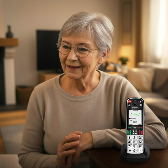 Una persona mayor habla por teléfono con el teléfono fijo inalámbrico Gigaset EASY 500
