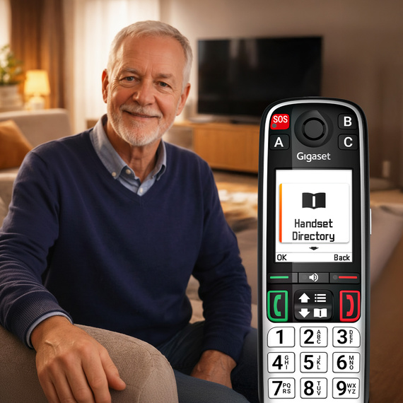 Persona mayor con el teléfono Gigaset EASY 500 de teclas grandes en casa